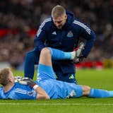 Newcastle goalkeeper Aaron Ramsdale receives treatment for an injury against Manchester United