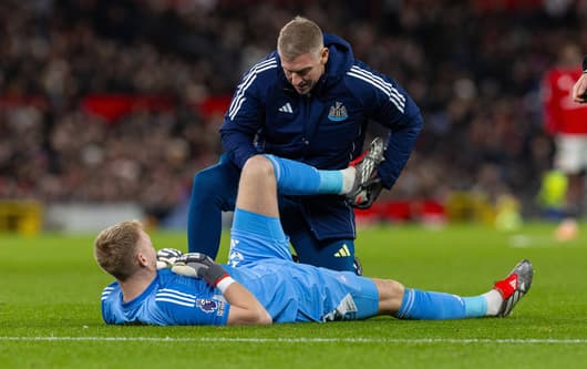 Newcastle goalkeeper Aaron Ramsdale receives treatment for an injury against Manchester United