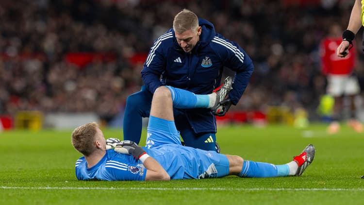 Newcastle goalkeeper Aaron Ramsdale receives treatment for an injury against Manchester United