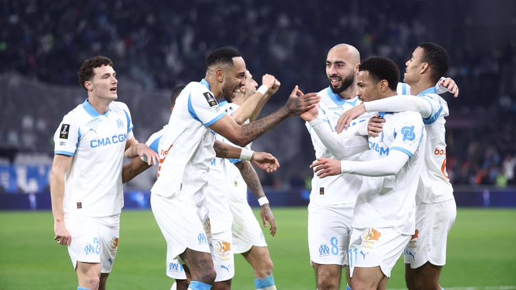 Marseille players crowd Ethan Nwaneri after he set up Pierre-Emerick Aubameyang's winner against Lyon