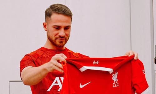 Alexis Mac Allister holding the Liverpool 2023-24 jersey