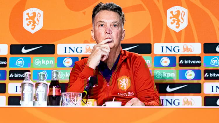 Louis van Gaal luistert aandachtig naar een vraag tijdens een persconferentie.