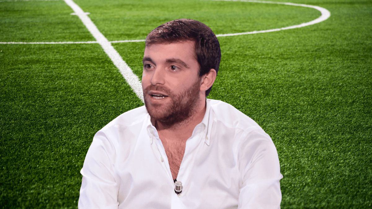 Headshot of Fabrizio Romano in front of a football pitch background
