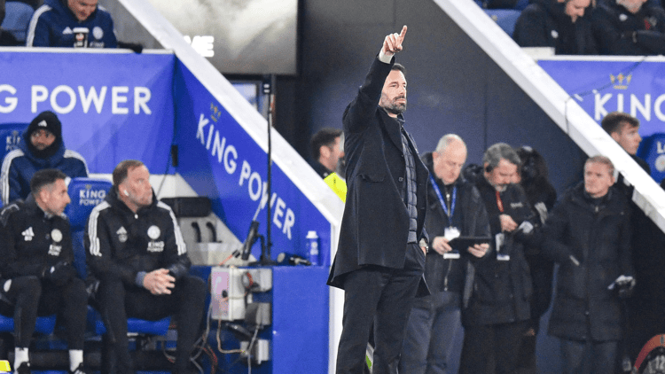 Jelle ten Rouwelaar zittend achter Ruud van Nistelrooij op de bank bij Leicester City