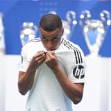 Kylian Mbappe kisses the Real Madrid badge at his presentation, 2024
