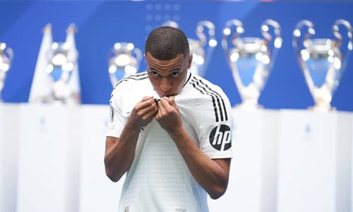Kylian Mbappe kisses the Real Madrid badge at his presentation, 2024