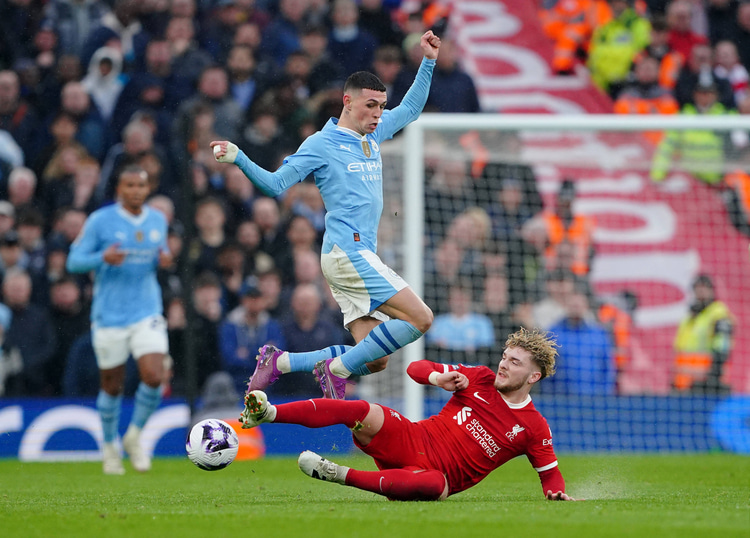Harvey Elliot glijdt Manchester City-speler Phill Foden van de bal.