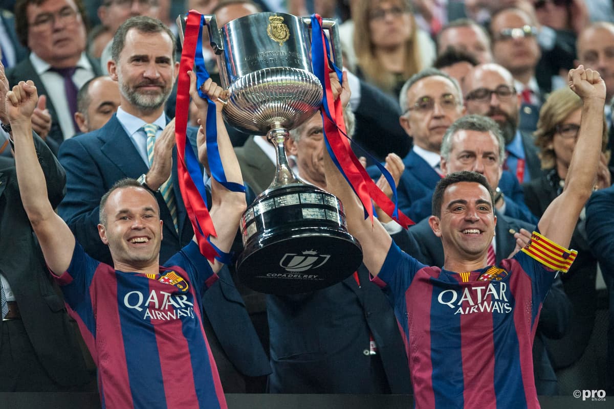 Andres Iniesta and Xavi lift trophy together for Barcelona