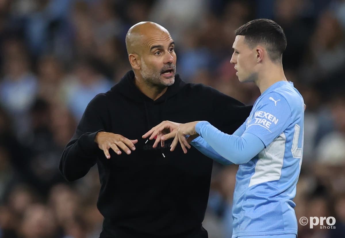 Man City boss Pep Guardiola chats to Phil Foden during a Champions League tie with PSG