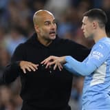 Man City boss Pep Guardiola chats to Phil Foden during a Champions League tie with PSG