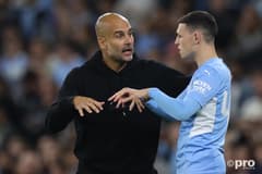 Man City boss Pep Guardiola chats to Phil Foden during a Champions League tie with PSG
