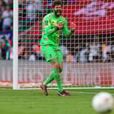 Alisson celebrates as Liverpool win the FA Cup on penalties.