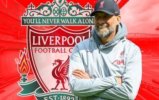 Jurgen Klopp and the Liverpool badge, in front of a panorama of Anfield in red