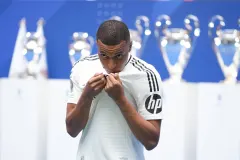 Kylian Mbappe kisses the Real Madrid badge at his presentation, 2024