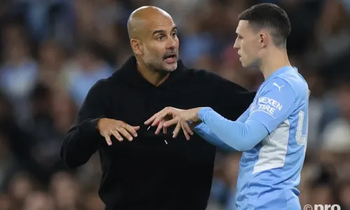 Man City boss Pep Guardiola chats to Phil Foden during a Champions League tie with PSG