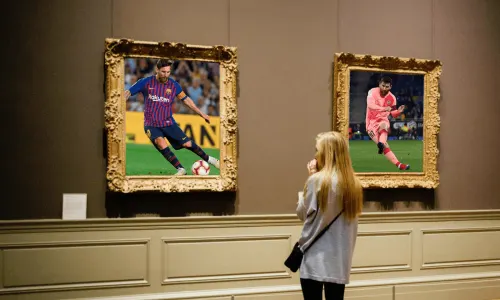Woman looking at Lionel Messi pictures in a museum