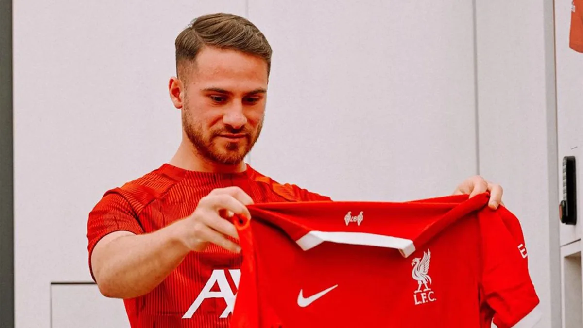 Alexis Mac Allister holding the Liverpool 2023-24 jersey