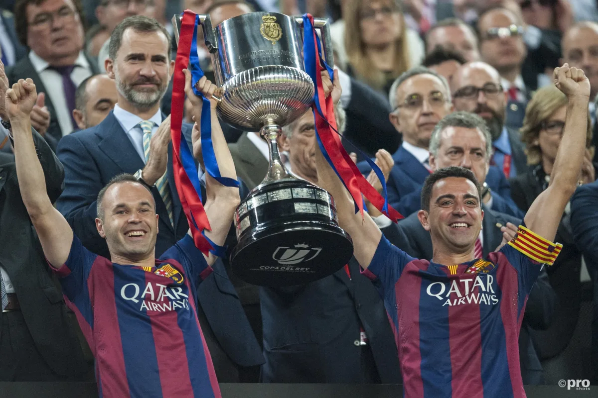 Andres Iniesta and Xavi lift trophy together for Barcelona